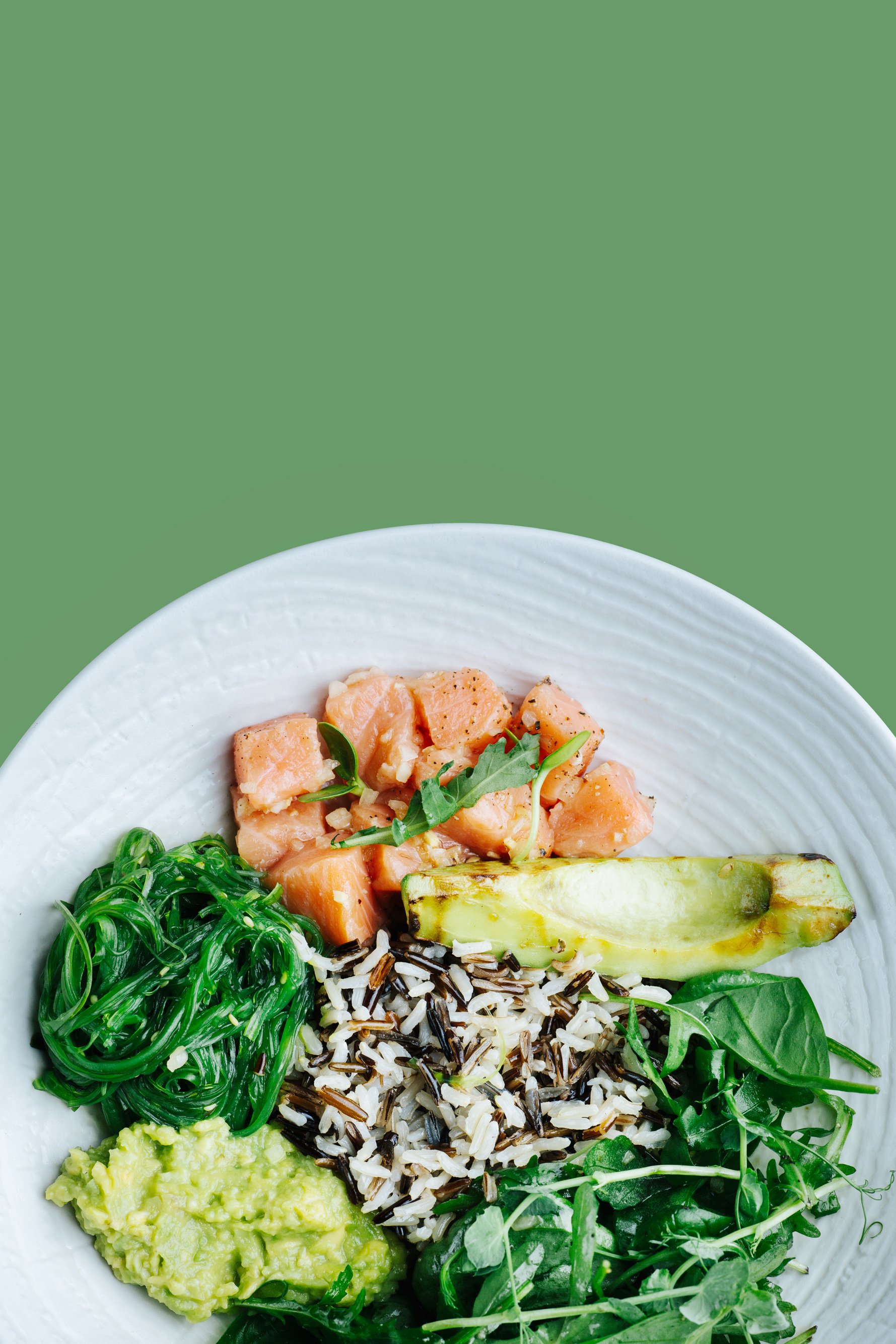 Healthy meal: salted salmon with avocado, spinach, seaweed and brown rice